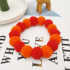 A circular collar made of bright orange and red felt flowers, displayed on a white background.