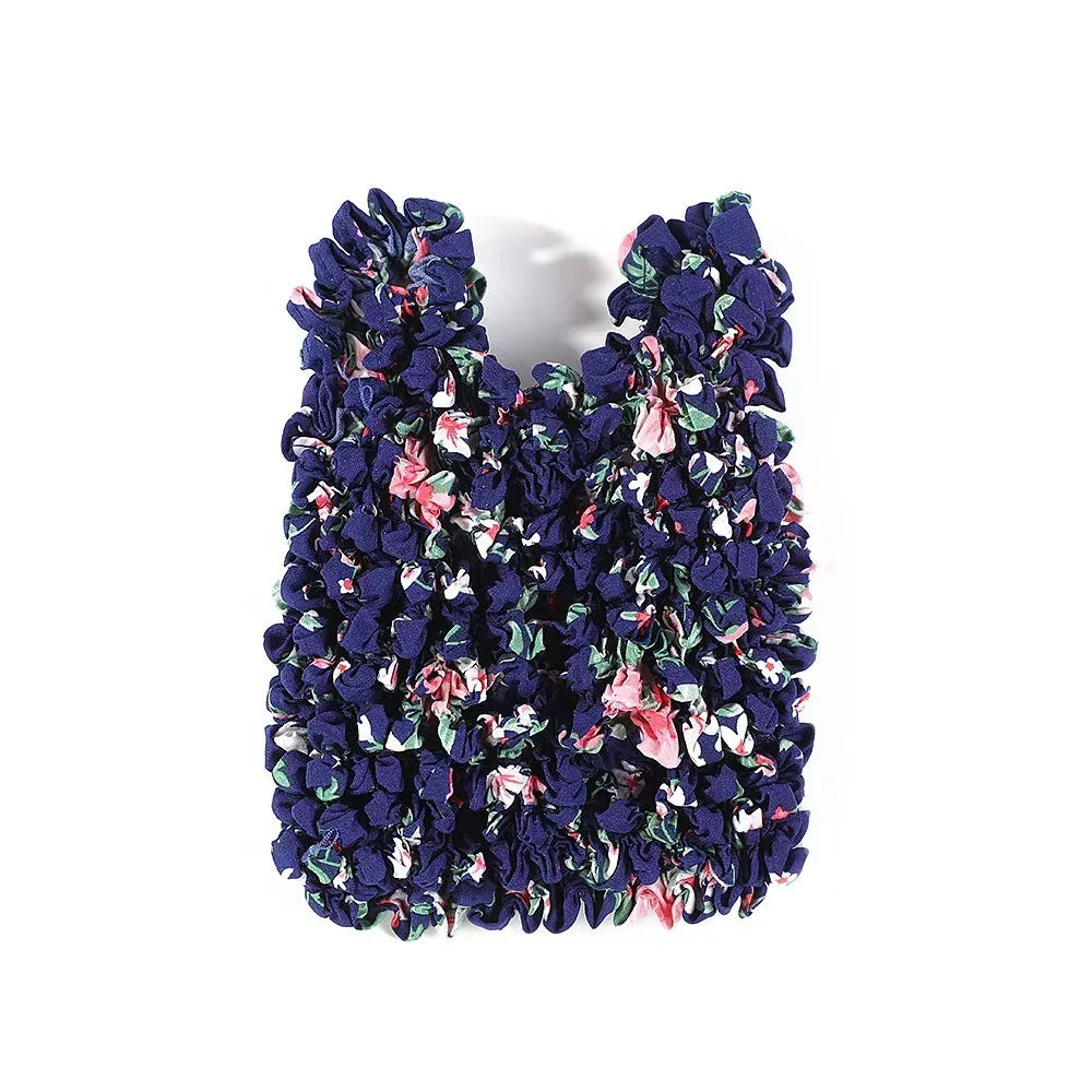 A reusable foldable bubble shopping bag made of dark blue and pink floral fabric.