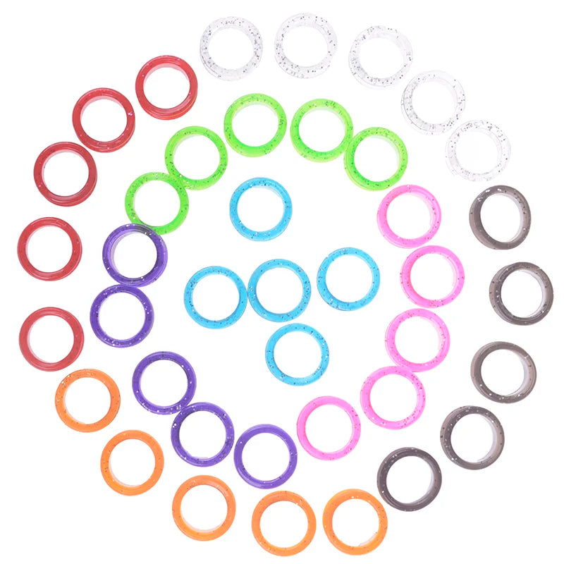 A collection of colorful silica gel hair scissors rings arranged in a circular pattern.