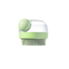 A light green silicone pet bath brush with a clear shampoo dispenser.