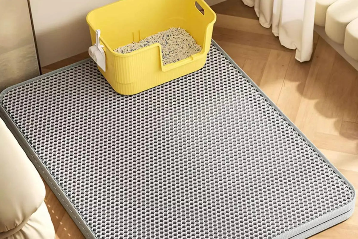 Gelierte, wasserdichte Katzenstreumatte in Gelb auf einer grauen strukturierten Matte drinnen.