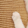 A close-up of a beige sisal scratching post with white fur visible.