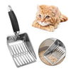 A stainless steel cat litter scoop with a long handle next to an orange tabby kitten.