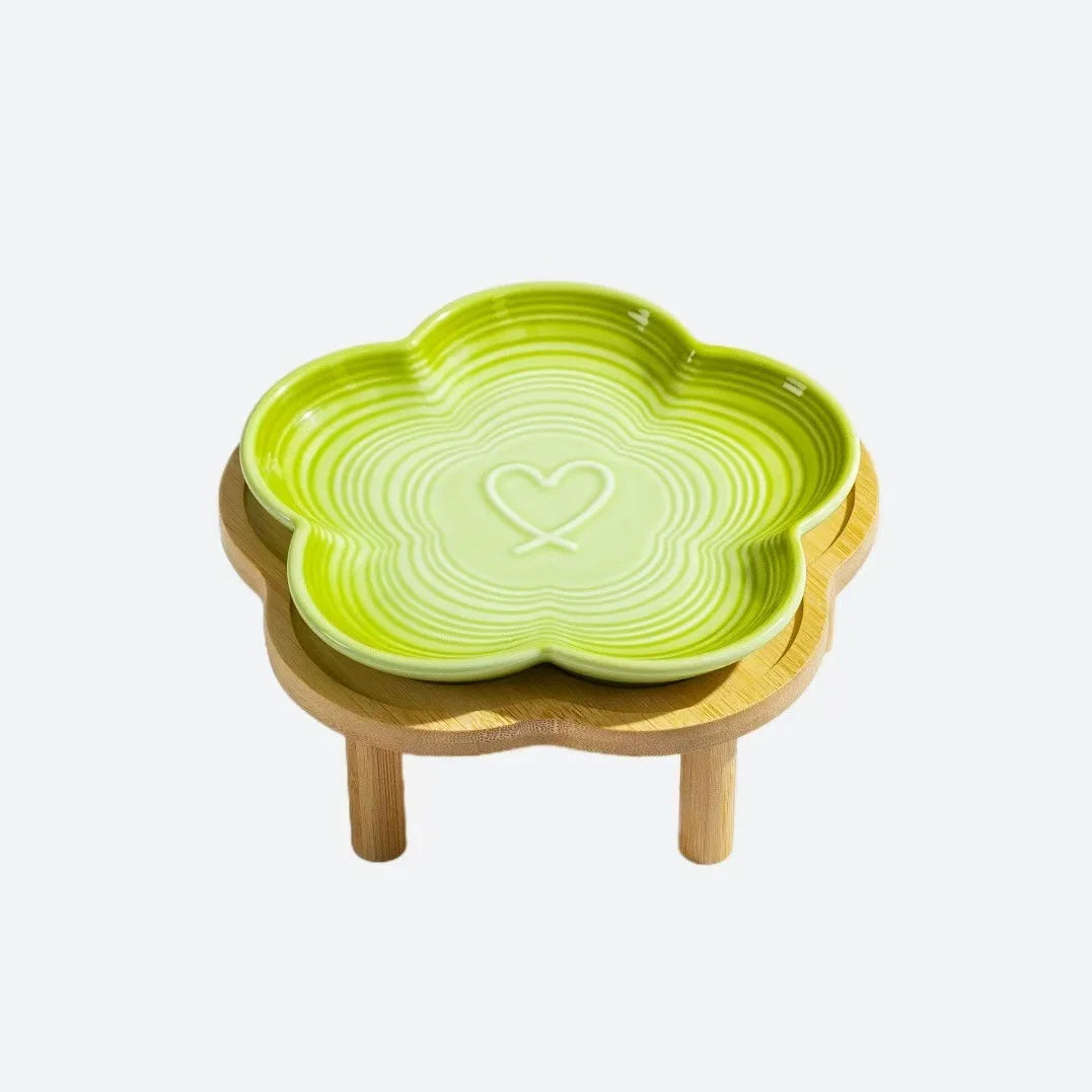Un bol pour animaux en céramique avec un motif de cœur sur un support en bois naturel.