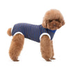 A fluffy brown dog wearing a blue and navy striped cotton recovery suit with white trim.