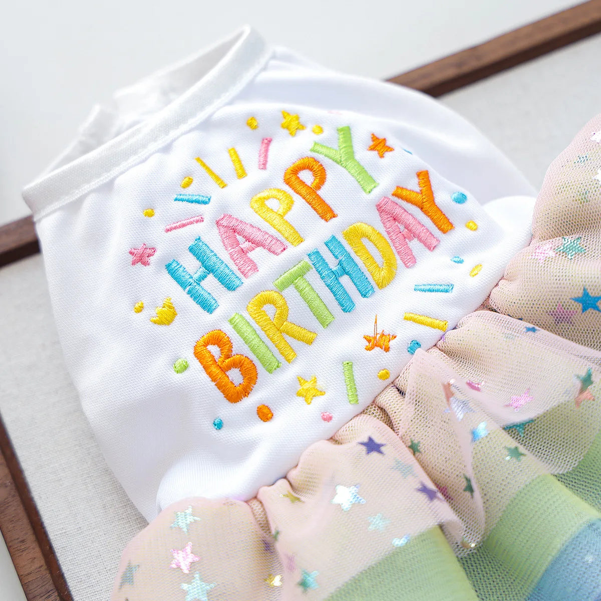 White birthday suit for dogs made of tulle with colorful lettering