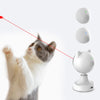 A domestic cat is interacting with an automatic laser toy, which is a white device with a green light.