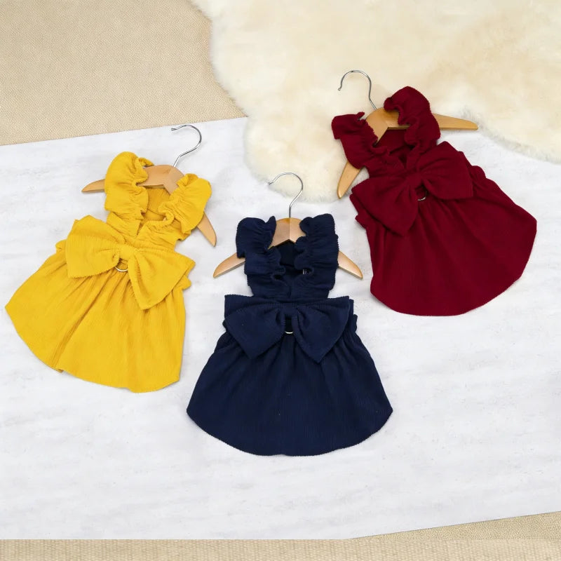 A vintage corduroy pet dress in yellow, navy blue, and burgundy colors displayed on a white surface.