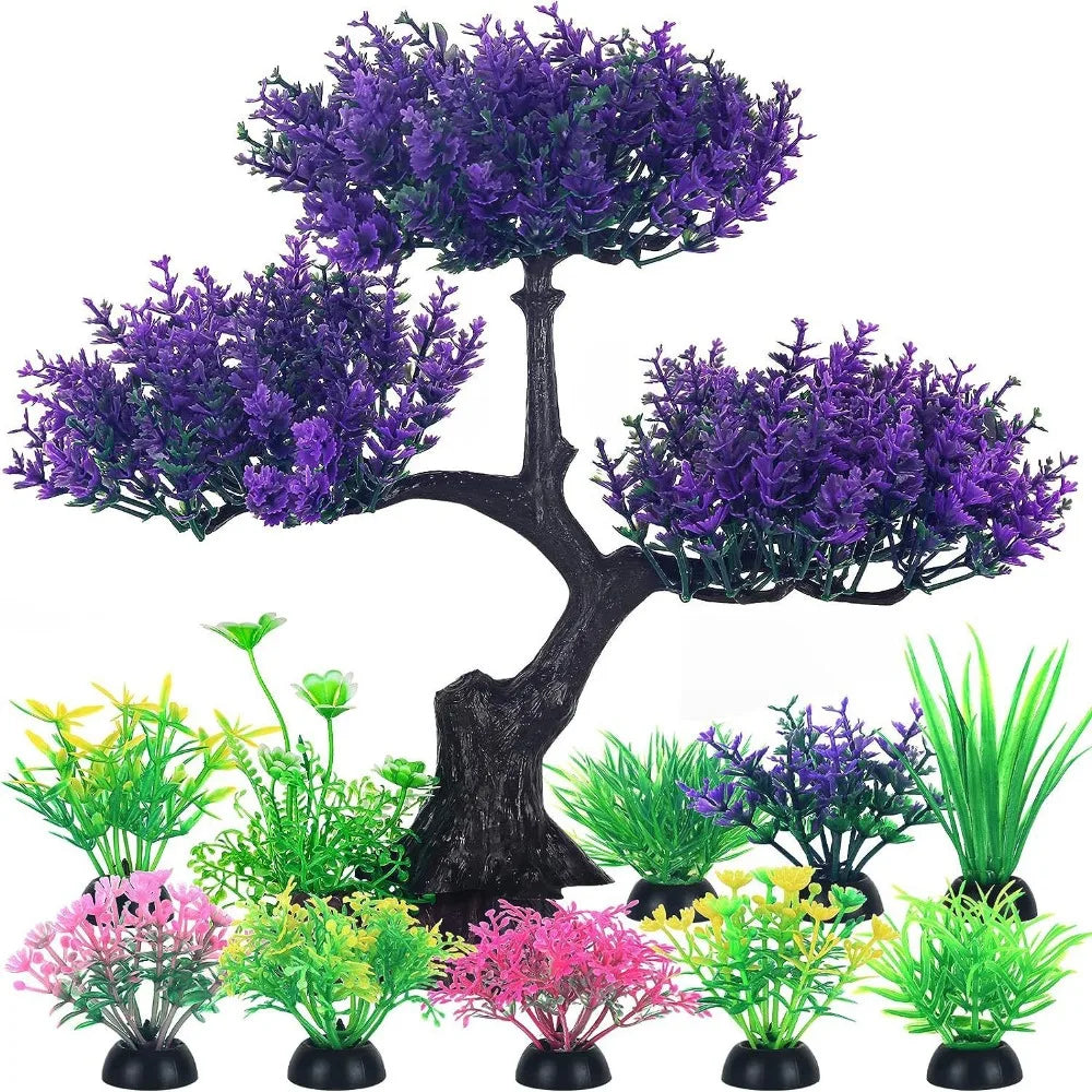 Colección de plantas acuáticas artificiales realistas en tonos verdes y morados sobre un tronco de árbol negro.