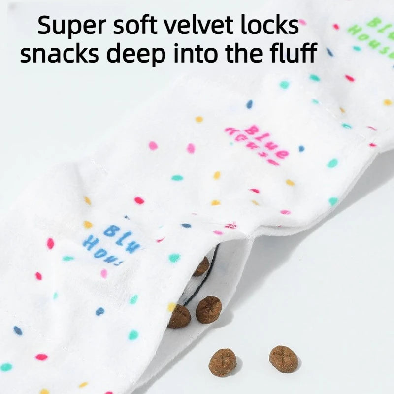 A close-up of a white snuffle toy for dogs with blue and pink accents, showing the soft velvet locks inside.