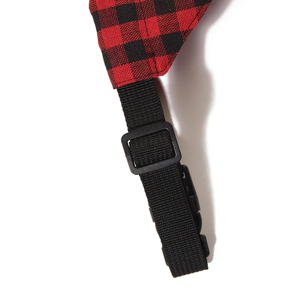 A black adjustable pet bandana scarf with a red and black plaid pattern.