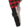 A black adjustable pet bandana scarf with a red and black plaid pattern.