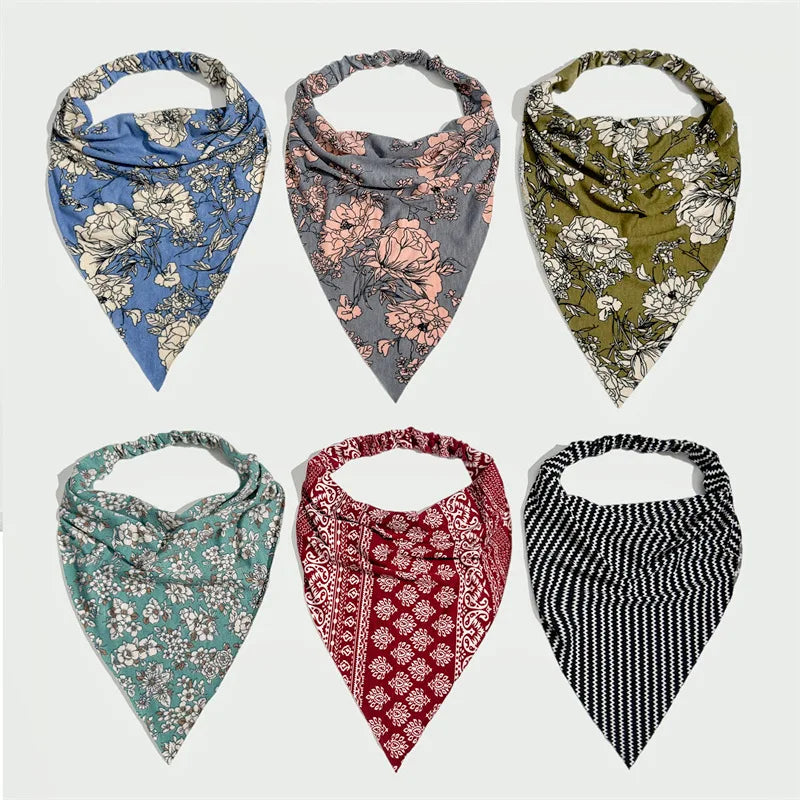 Cuatro pañuelos de tela con estampados florales en azul, rosa, verde oliva y blanco.