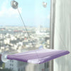 A purple hanging cat hammock window perch suspended by thin lines and suction cups, viewed from below.