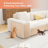 A white fabric sofa with beige protective covers is shown on a light rug with a cat nearby.