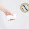 A hand holds a white lint roller refill, next to a blue cloud-shaped storage case.