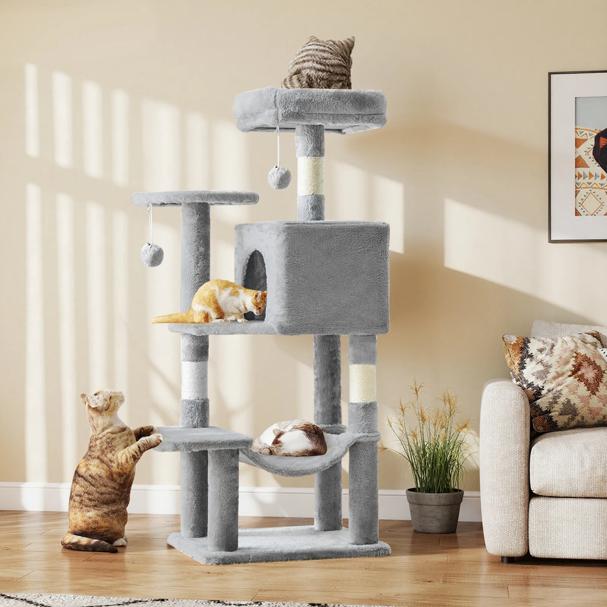 A multi-level sisal cat climbing tree with gray and beige sisal rope, featuring a cat toy and a tabby kitten.