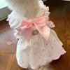 Weißes Hundekleid mit Rüschenkragen und Rock mit rosa Herzmusterdetails.