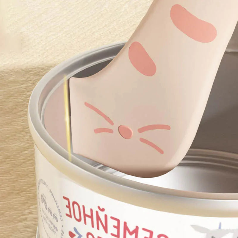 A silicone pet can opener and feeding spoon with a sealing lid featuring a pink cat design.