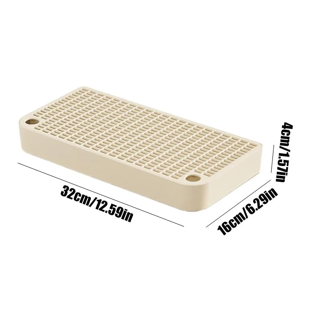 A rectangular beige cat litter box ramp step with a grid texture and filter tray.