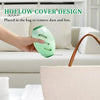 A hand holds a green reusable gel lint roller designed for removing dust and lint.