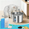 A silver cat water fountain with running water, surrounded by replacement filters and sponges.