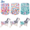 Reusable female dog diapers in various floral patterns and colors shown alongside a fluffy dog model.