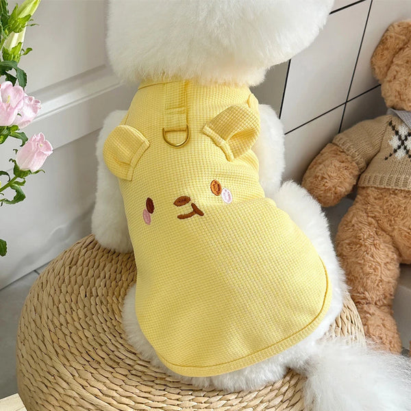 A yellow waffle knit pet vest for a dog or cat is displayed on a woven surface.