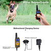 A dog is running in a grassy field next to a hand holding a yellow remote control device and its charging cable.
