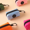 Collection de petits sacs à fermeture éclair roses, verts et bleus avec attaches à carabiner sur fond clair.