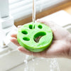 Eine Hand hält einen leuchtend grünen wiederverwendbaren Haarentferner für Haustiere mit Löchern, der Wasser tropft.