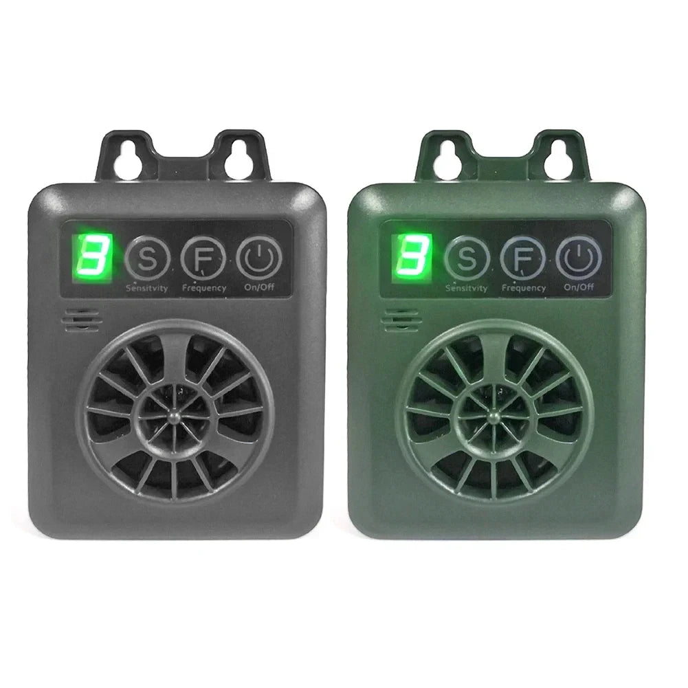 A pair of gray and green ultrasonic anti-barking devices for dogs, showing the on/off switch and sensitivity settings.