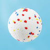 A white, textured chew ball speckled with small, brightly colored, bite-resistant pieces for dogs.