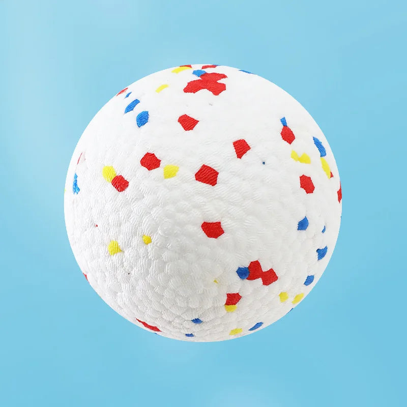 A white, textured chew ball speckled with small, brightly colored, bite-resistant pieces for dogs.
