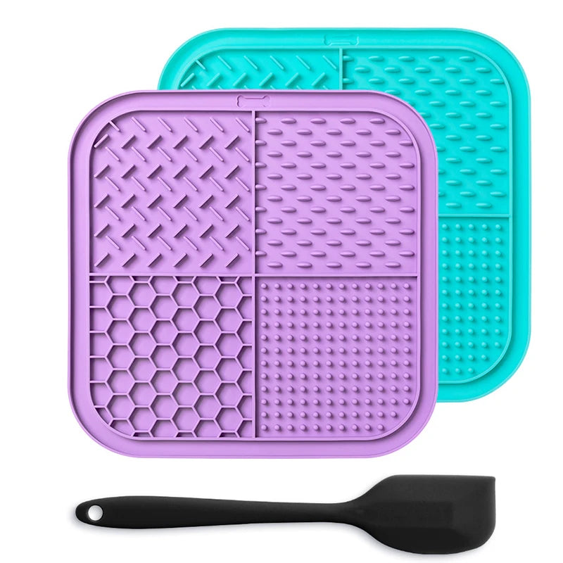 A purple silicone lick mat for pets is shown next to a black silicone spoon.