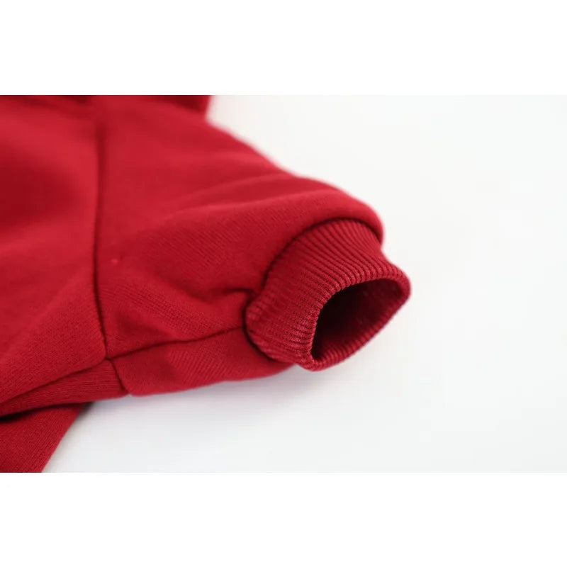 A close-up view of a red cozy fleece dog sweatshirt with ribbed cuffs and collar.