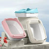 Three stacked white and pink cat litter boxes with blue lids on a gray surface.