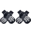 Pair of black dog socks with white paw print traction straps