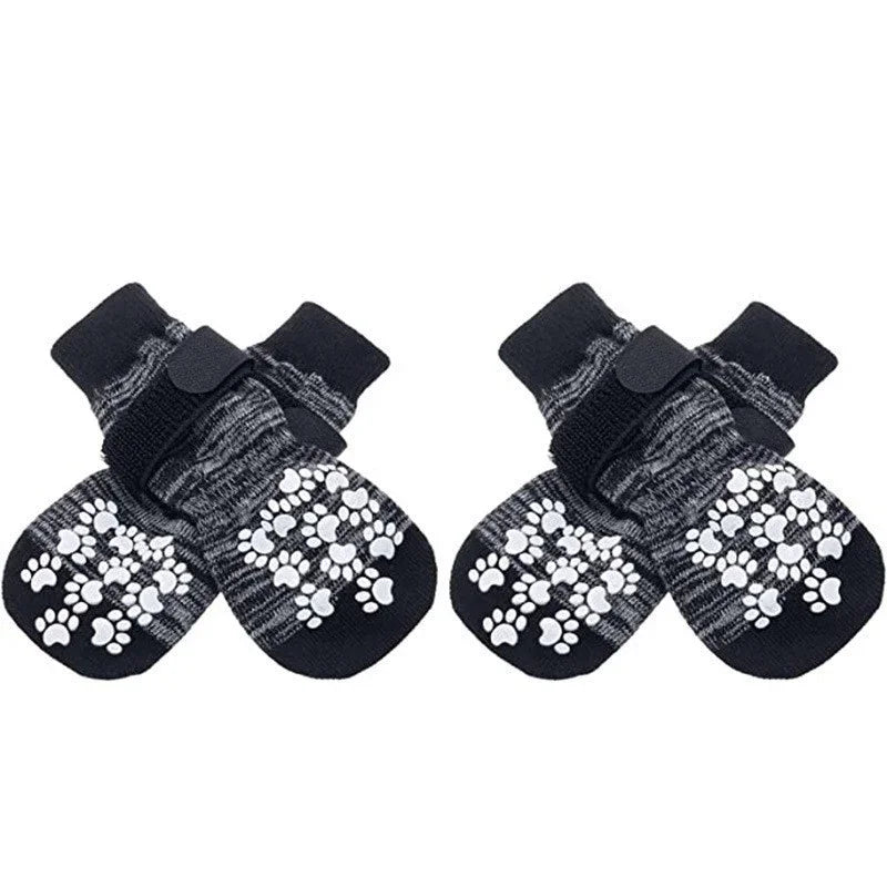 Pair of black dog socks with white paw print traction straps