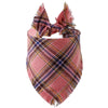 A plaid dog bandana in shades of pink, brown, and blue with fringed edges.
