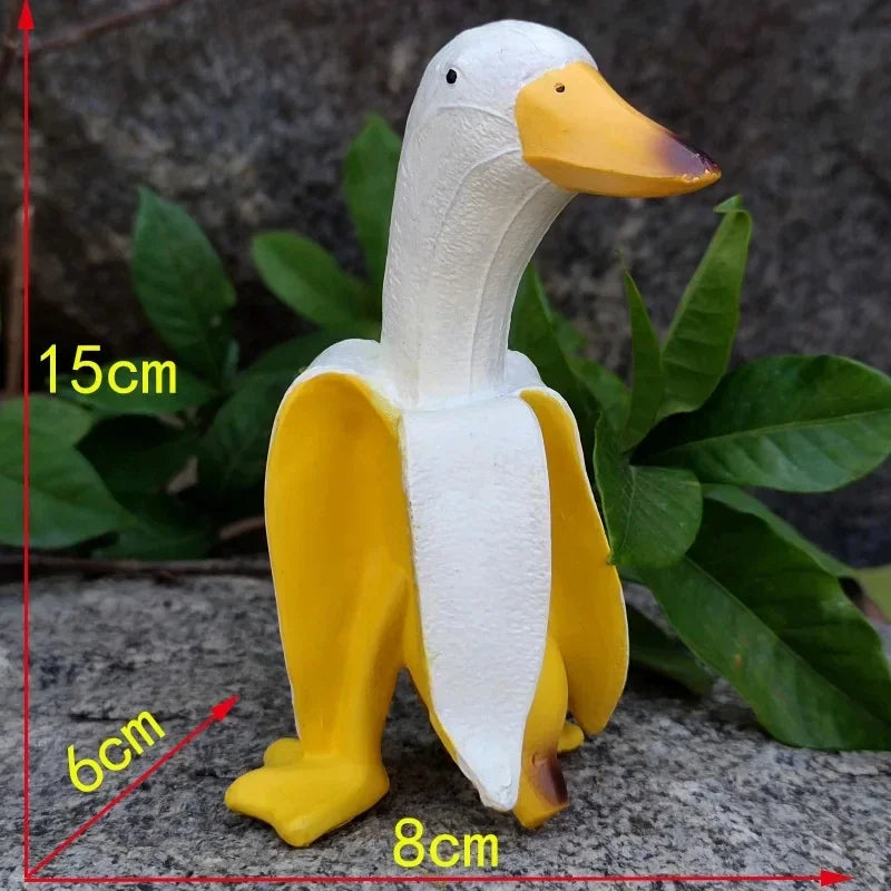 A white and yellow resin banana duck garden sculpture shown in a side view with dimensions marked.