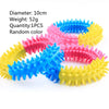 A collection of colorful rubber chew toys for dogs, including yellow, pink, and blue, arranged in a circle.