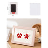 A pink wooden photo frame with a red paw print design, shown on a wooden surface.