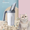 A gray reusable pet litter scoop is shown next to a cat, with loose litter scattered on the floor.