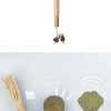 A natural silvervine cat chew stick with a fluffy feather and dried plant material attached.