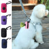 A white poodle wearing a mesh dog waste bag dispenser with a light pink tag and green fabric.