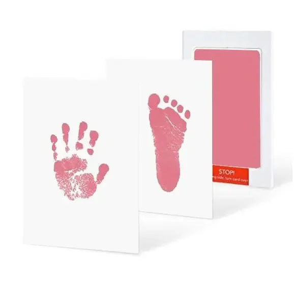 A white card with a pink handprint and footprint design next to a pink card with a rectangular cutout.