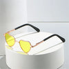 Funny heart-shaped pet sunglasses with gold-toned frames and yellow lenses resting on a white surface