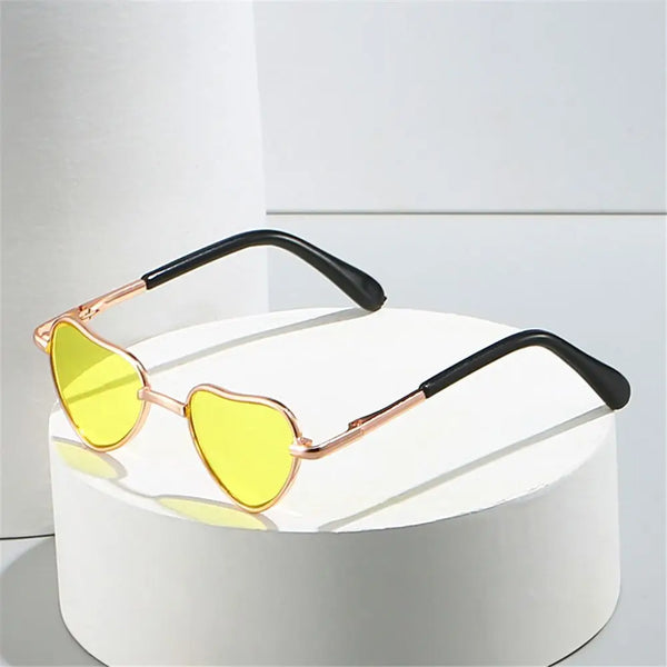 Lustige herzförmige Hundesignbrille mit goldfarbenen Rahmen und gelben Linsen auf weißem Untergrund