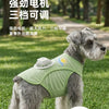 A gray dog wearing a light green cooling vest with a built-in fan, outdoors on grass.